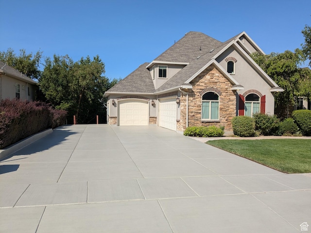 1711 N Compton Rd, Farmington, UT 84025 - view of front facade with an attached garage, stone siding, concrete driveway, stucco siding, and roof with shingles