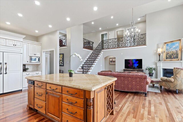 1711 N Compton Rd, Farmington, UT 84025 - kitchen with stainless steel microwave, a high ceiling, open floor plan, light wood finished floors, and a center island