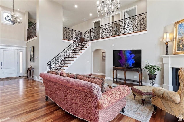 1711 N Compton Rd, Farmington, UT 84025 - living room with a chandelier, a high ceiling, stairs, wood finished floors, and arched walkways