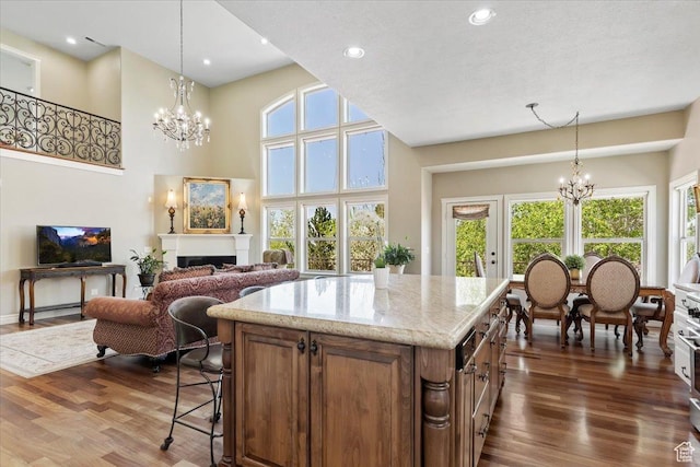 1711 N Compton Rd, Farmington, UT 84025 - kitchen featuring a chandelier, dark wood finished floors, brown cabinetry, hanging light fixtures, and recessed lighting