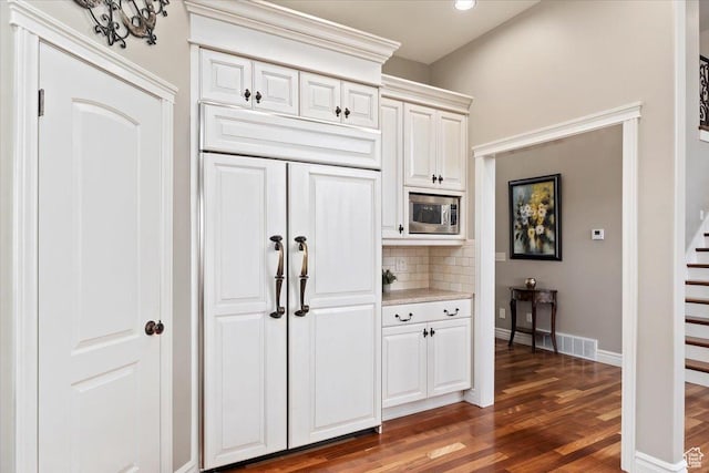 1711 N Compton Rd, Farmington, UT 84025 - kitchen with wood finished floors, built in appliances, backsplash, light countertops, and white cabinetry