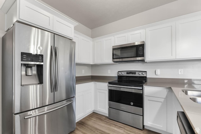 4234 W Mckellen Dr S Unit G301, Herriman, UT 84096 - kitchen with appliances with stainless steel finishes, white cabinetry, and light wood-type flooring