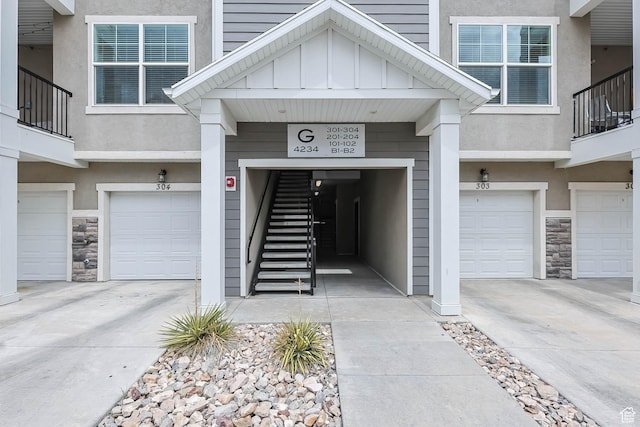 4234 W Mckellen Dr S Unit G301, Herriman, UT 84096 - doorway to property featuring stone siding, an attached garage, and driveway