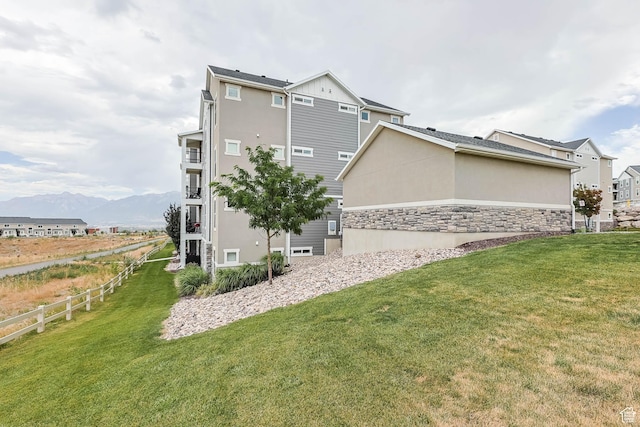 4234 W Mckellen Dr S Unit G301, Herriman, UT 84096 - rear view of property featuring a mountain view, stucco siding, and stone siding