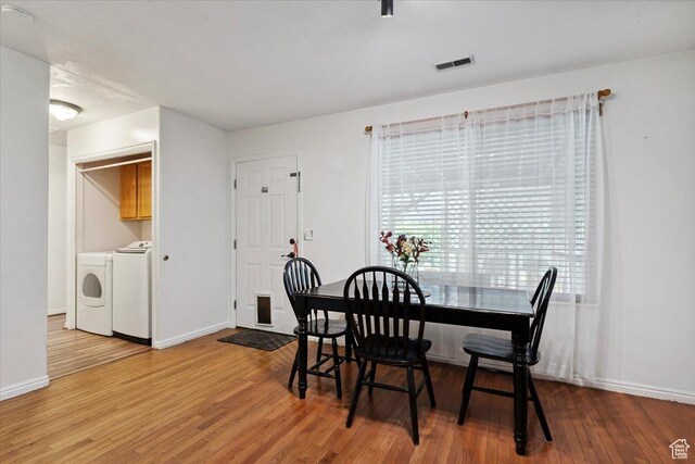 2793 S Cyprus Grove Cir W, Magna, UT 84044 - dining room with washing machine and clothes dryer, wood finished floors, and plenty of natural light