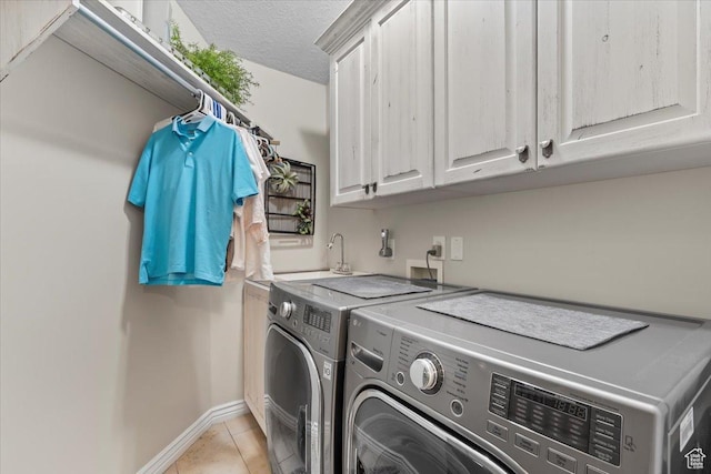 1677 E Wylie Ln, Draper, UT 84020 - laundry area featuring washer and clothes dryer, cabinet space, light tile patterned floors, and a textured ceiling