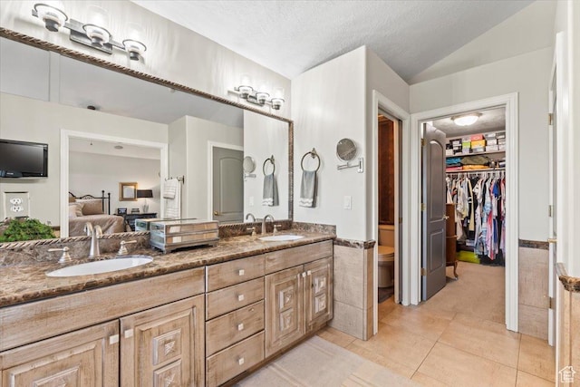 1677 E Wylie Ln, Draper, UT 84020 - full bathroom with double vanity, ensuite bath, a walk in closet, wainscoting, and tile patterned floors