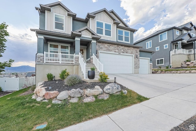 499 N Stone Ridge Dr, Saratoga Springs, UT 84045 - craftsman house with stone siding, board and batten siding, driveway, a garage, and a porch