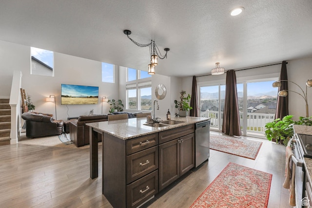 499 N Stone Ridge Dr, Saratoga Springs, UT 84045 - kitchen with stainless steel appliances, dark brown cabinetry, a textured ceiling, pendant lighting, and light stone counters
