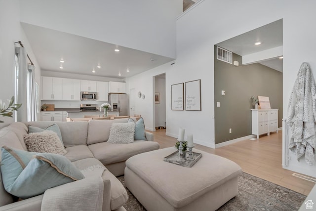 3444 Sparrow Ln W Unit 164, Eagle Mountain, UT 84005 - living area featuring light wood-style flooring, recessed lighting, and a towering ceiling