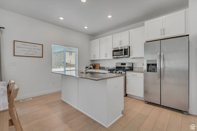 3444 Sparrow Ln W Unit 164, Eagle Mountain, UT 84005 - kitchen with stainless steel appliances, light wood finished floors, white cabinetry, a kitchen island with sink, and recessed lighting
