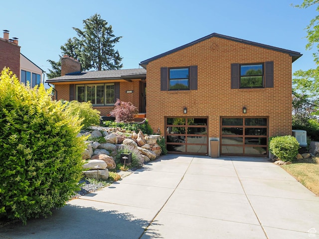 2680 E 2100th St S Unit 44-45, Salt Lake City, UT 84109 - view of front of house with driveway, a garage, brick siding, and a chimney