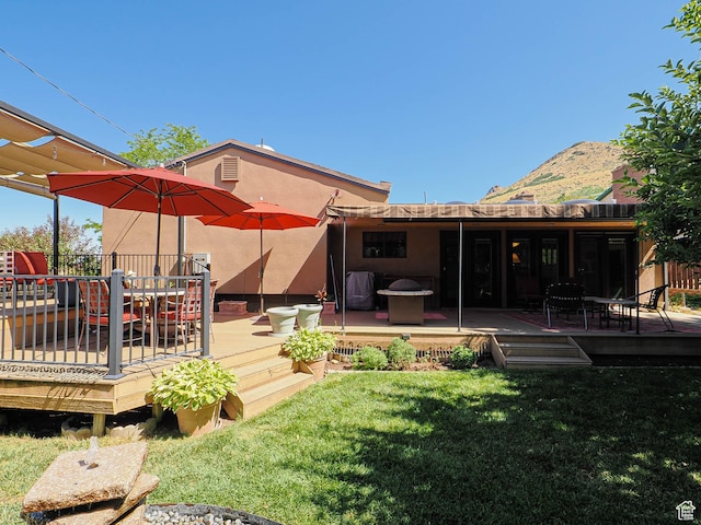 2680 E 2100th St S Unit 44-45, Salt Lake City, UT 84109 - rear view of house with a lawn, a deck with mountain view, and stucco siding