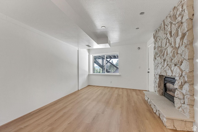 575 Upper Evergreen Dr, Park City, UT 84098 - unfurnished living room with light wood-style floors, a textured ceiling, and a fireplace