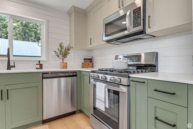575 Upper Evergreen Dr, Park City, UT 84098 - kitchen featuring green cabinets, appliances with stainless steel finishes, light wood-style floors, light countertops, and backsplash