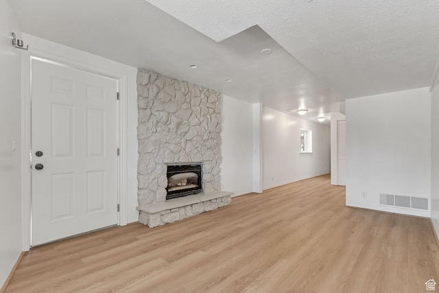 575 Upper Evergreen Dr, Park City, UT 84098 - unfurnished living room with wood finished floors, a stone fireplace, and a textured ceiling