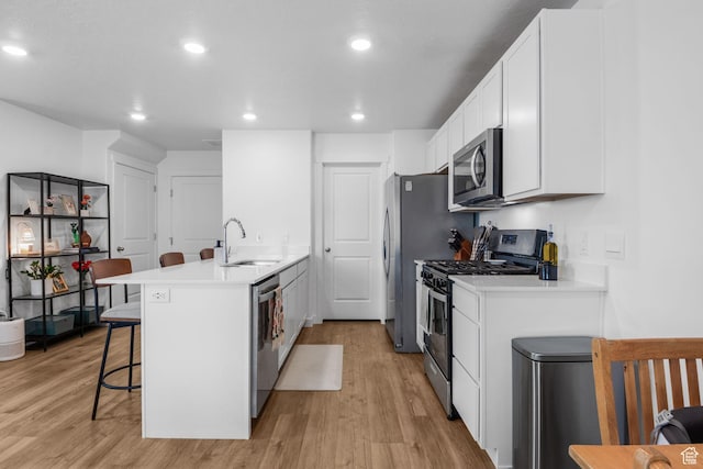 943 E Drifter Ln, Saratoga Springs, UT 84045 - kitchen with appliances with stainless steel finishes, a breakfast bar, light wood-style floors, a peninsula, and recessed lighting