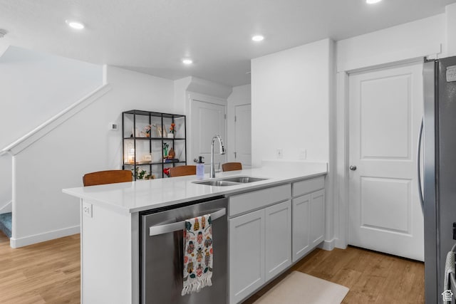943 E Drifter Ln, Saratoga Springs, UT 84045 - kitchen with appliances with stainless steel finishes, a peninsula, light wood-type flooring, light countertops, and recessed lighting