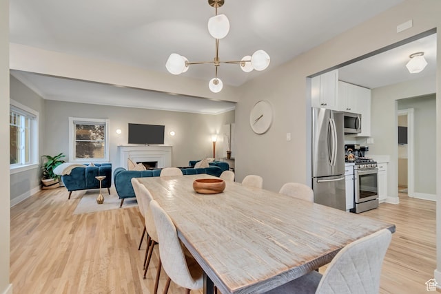 1221 E 800 S, Salt Lake City, UT 84102 - dining space featuring light wood-type flooring, a chandelier, and a fireplace