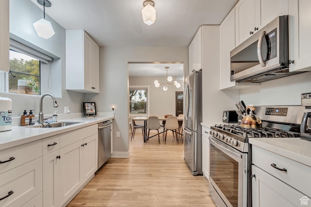 1221 E 800 S, Salt Lake City, UT 84102 - kitchen with appliances with stainless steel finishes, light wood-type flooring, white cabinets, light countertops, and hanging light fixtures