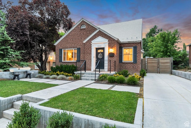1221 E 800 S, Salt Lake City, UT 84102 - bungalow-style house with brick siding, a front yard, concrete driveway, and a gate