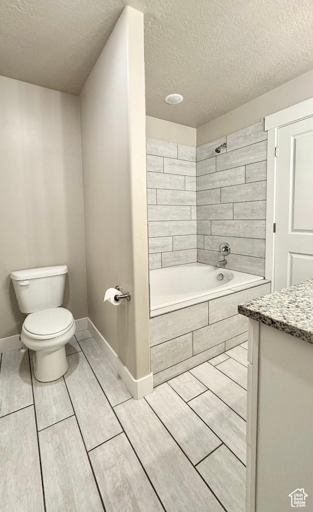 2408 E Maple Dr, Eagle Mountain, UT 84005 - bathroom featuring a textured ceiling, vanity, tile patterned flooring, and tiled shower / bath