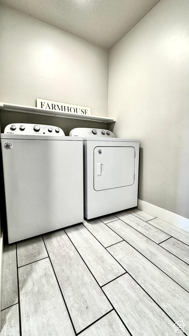 2408 E Maple Dr, Eagle Mountain, UT 84005 - laundry area featuring washer and clothes dryer, a textured ceiling, and wood tiled floors