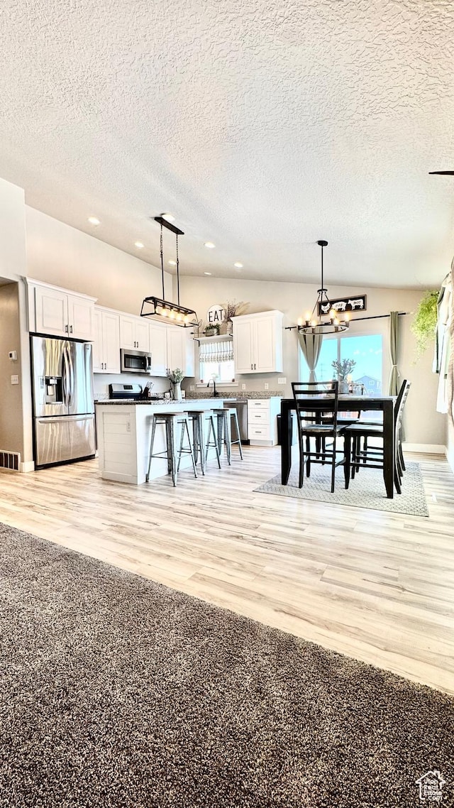 2408 E Maple Dr, Eagle Mountain, UT 84005 - dining area featuring a textured ceiling, recessed lighting, light wood-style floors, and a chandelier