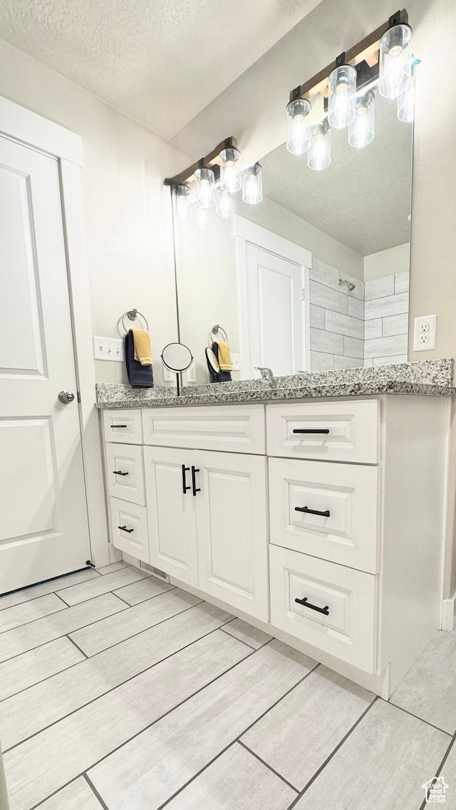 2408 E Maple Dr, Eagle Mountain, UT 84005 - bathroom featuring a textured ceiling and vanity