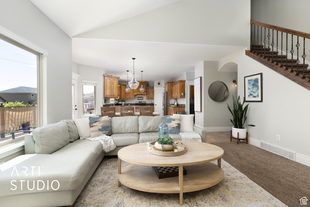 2244 S Hunter Dr, Saratoga Springs, UT 84045 - living area featuring light carpet, stairway, and high vaulted ceiling