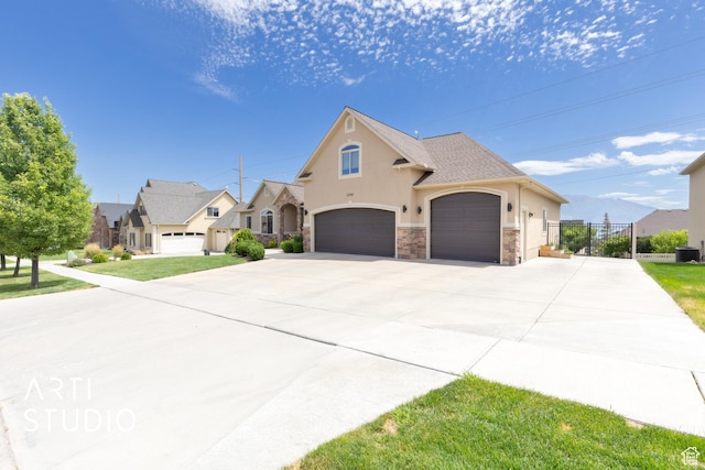 2244 S Hunter Dr, Saratoga Springs, UT 84045 - view of front of house with stucco siding, stone siding, driveway, and an attached garage