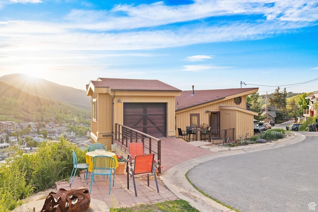 235 Mchenry Ave, Park City, UT 84060 - view of front of house with a patio, a mountain view, a garage, and a shingled roof