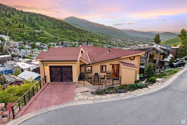 235 Mchenry Ave, Park City, UT 84060 - view of front of property with a mountain view, an attached garage, decorative driveway, and roof with shingles