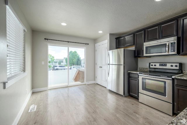 1728 E Shadow Dr, Eagle Mountain, UT 84005 - kitchen with appliances with stainless steel finishes, light wood-type flooring, recessed lighting, light stone counters, and a textured ceiling