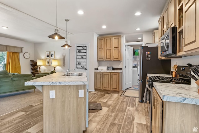 516 N Broadway Ave, Tooele, UT 84074 - kitchen featuring stainless steel microwave, open floor plan, black gas stove, light wood-style floors, and light countertops