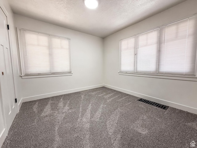 3561 S Grant Ave E, Ogden, UT 84401 - empty room with dark carpet and a textured ceiling