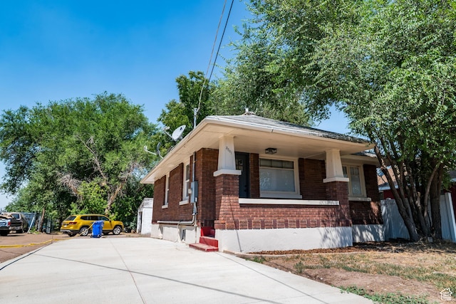 3561 S Grant Ave E, Ogden, UT 84401 - view of front of house with brick siding, driveway, and a porch