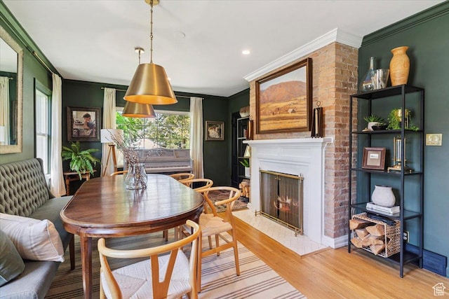 93 S 200 E, Kaysville, UT 84037 - dining room featuring light wood-style flooring, crown molding, and a lit fireplace