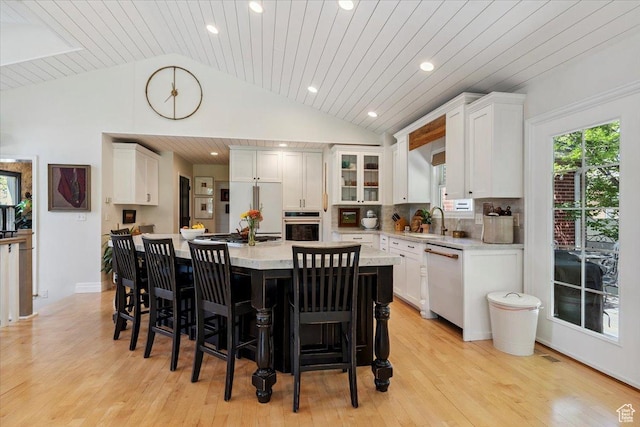 93 S 200 E, Kaysville, UT 84037 - kitchen featuring white appliances, light countertops, vaulted ceiling, white cabinetry, and a kitchen bar