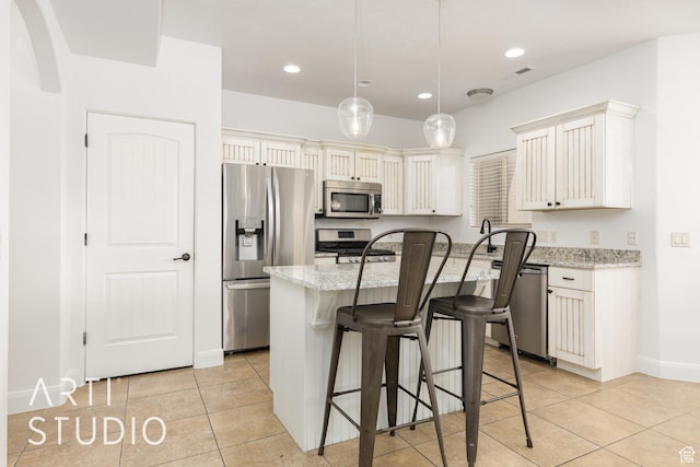 94 S 6175 W, Hurricane, UT 84737 - kitchen featuring appliances with stainless steel finishes, light tile patterned flooring, a kitchen bar, light stone counters, and a kitchen island with sink