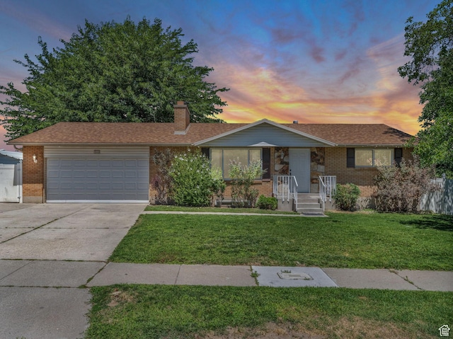 3112 W 5685 S, Taylorsville, UT 84129 - view of front of property with driveway, brick siding, an attached garage, a chimney, and a lawn