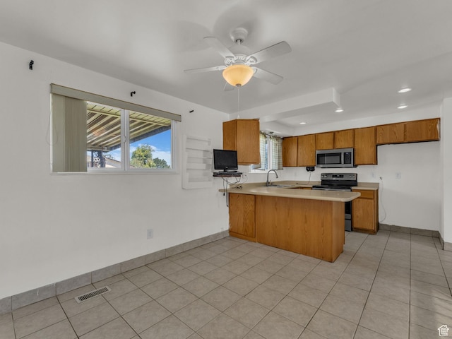3112 W 5685 S, Taylorsville, UT 84129 - kitchen with appliances with stainless steel finishes, a peninsula, brown cabinetry, light countertops, and ceiling fan