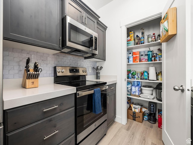 5084 E Lakefield Dr E, Eagle Mountain, UT 84005 - kitchen with stainless steel appliances, light countertops, decorative backsplash, and light wood-style floors
