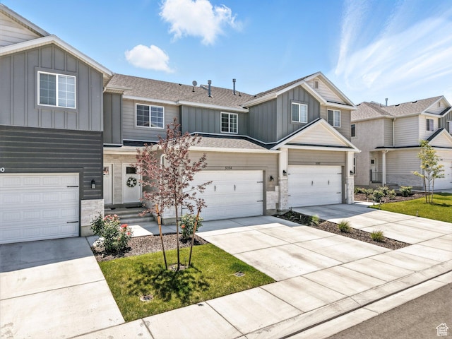 5084 E Lakefield Dr E, Eagle Mountain, UT 84005 - view of front of property with board and batten siding, concrete driveway, stone siding, an attached garage, and roof with shingles
