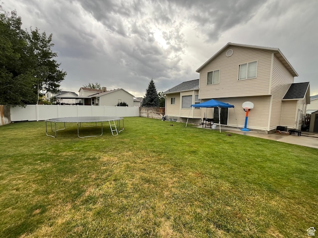 6433 S Laurel Canyon Dr W, Salt Lake City, UT 84118 - fenced backyard featuring a trampoline and a patio area
