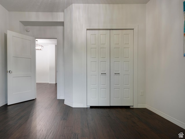 374 E 6th Ave, Salt Lake City, UT 84103 - unfurnished bedroom featuring dark wood-type flooring, a closet, and a chandelier