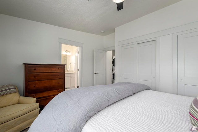 10465 S Beetdigger Blvd, Sandy, UT 84070 - bedroom with stacked washer / drying machine, a closet, a ceiling fan, and ensuite bath