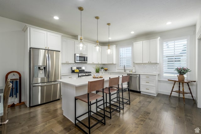 10465 S Beetdigger Blvd, Sandy, UT 84070 - kitchen featuring stainless steel appliances, a kitchen island, white cabinetry, a kitchen breakfast bar, and tasteful backsplash