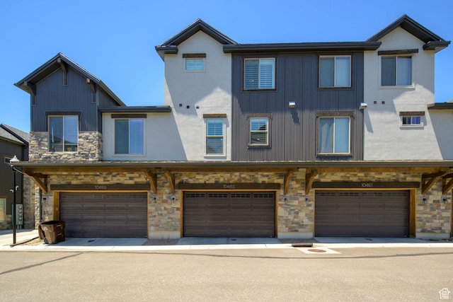10465 S Beetdigger Blvd, Sandy, UT 84070 - view of front of property with stone siding, an attached garage, stucco siding, and board and batten siding
