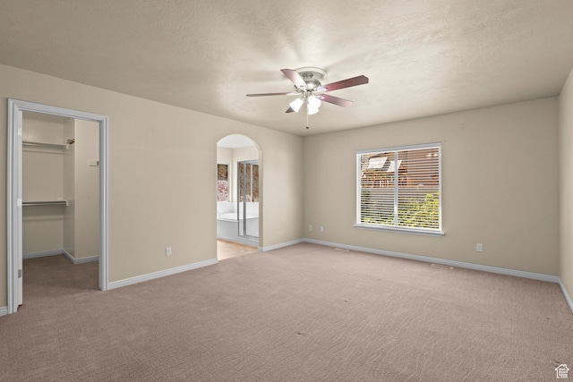 1221 S 130th St E, Payson, UT 84651 - unfurnished bedroom with light colored carpet, a walk in closet, arched walkways, ensuite bathroom, and ceiling fan